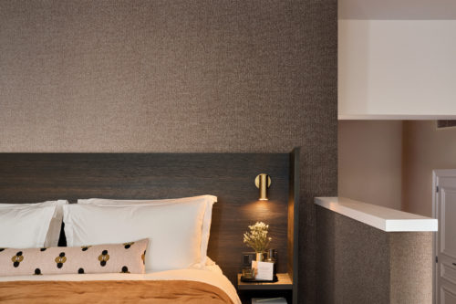 Versatile in design, Omexco's High Performance Essence wallpaper in warm textured browns enhances spa, bedroom, and workspace interiors with a refined, calming look.
