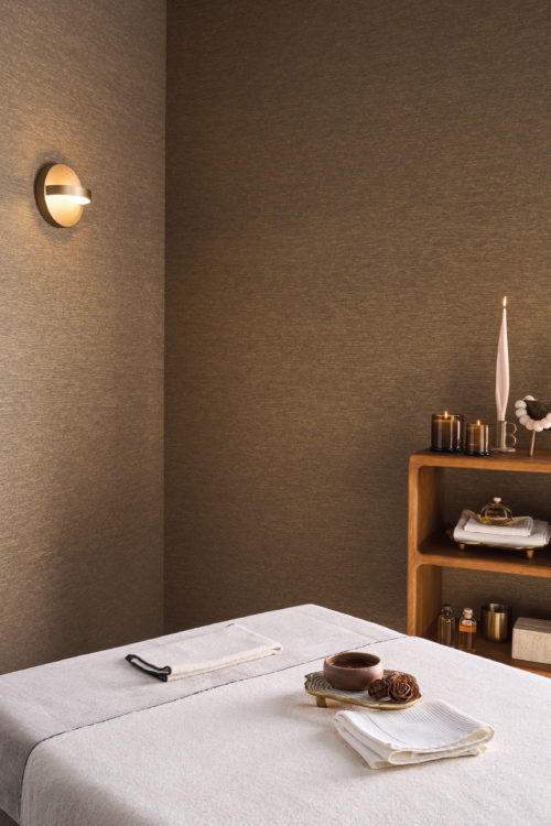 Versatile in design, Omexco's High Performance Essence wallpaper in warm textured browns enhances spa, bedroom, and workspace interiors with a refined, calming look.