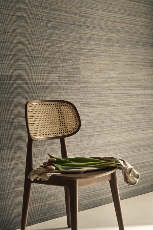 Omexco’s Virginia’s Garden wallpaper in soft blue-grey tones creates a refined and calming backdrop. Styled with a wooden chair and fresh tulips, the scene blends natural textures and gentle color for a serene, timeless interior.