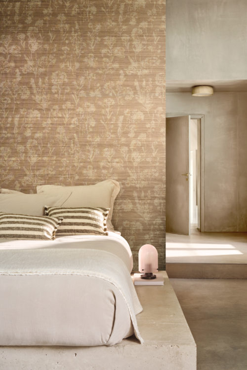 Omexco’s Virginia’s Garden collection brings soft floral wallpaper in warm beige, creating a serene bedroom atmosphere with natural light and minimal elegance.
