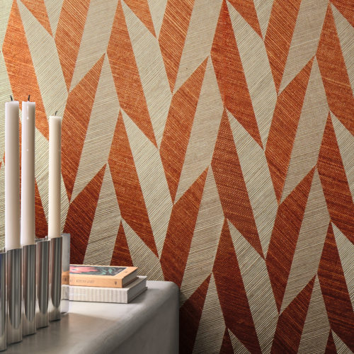 Omexco’s Virginia’s Garden collection brings a striking energy to interiors with this geometric wallpaper in vivid terracotta and soft neutrals. The dynamic leaf-inspired pattern creates movement and rhythm across the walls, transforming the space into a modern retreat where bold design meets natural influence. Styled with clean-lined furniture and soft light, the room balances warmth and sophistication.