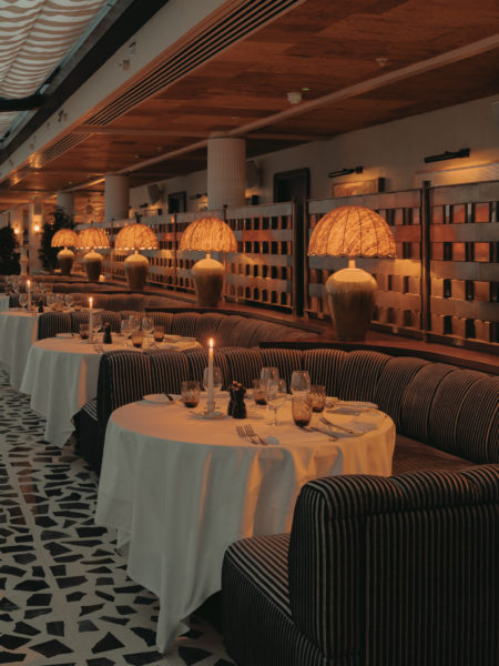 Inviting seating area at Soho House Manchester with layered textiles, soft lighting, indoor greenery and a natural mulberry bark ceiling overhead.